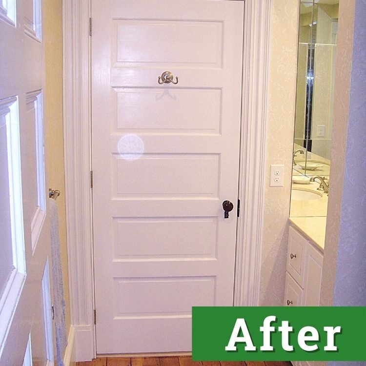 a newly installed white bathroom door and cabinetry