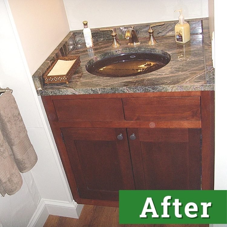 a mahogany bathroom cabinet with a black marble countertop