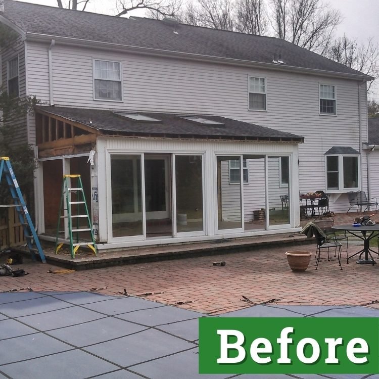 an unfinished addition with tall windows on the back of a light grey house