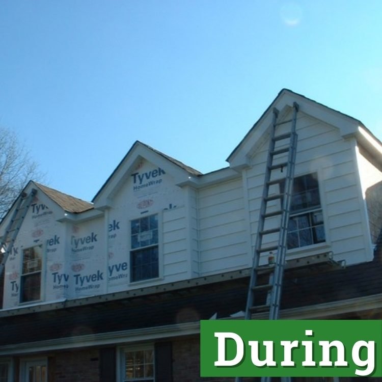 a ladder stretches to the second story of a nearly complete home addition