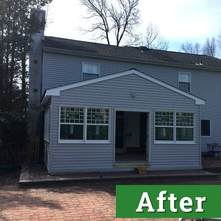 a newly built custom addition on the back of a light grey house