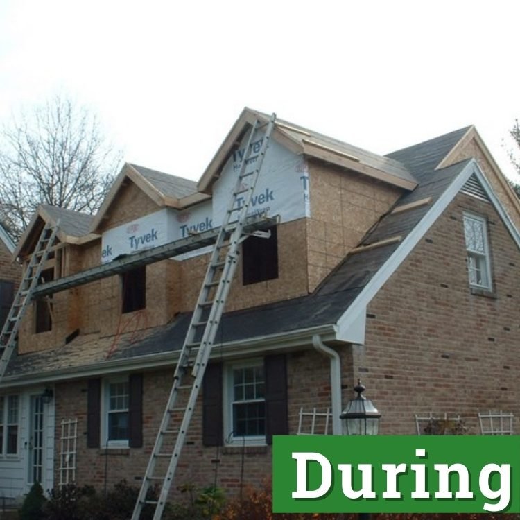 two ladders stretch to the second floor of a newly built home addition