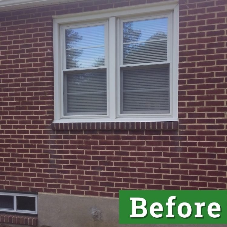 white double pane windows and a small basement window on a brick house