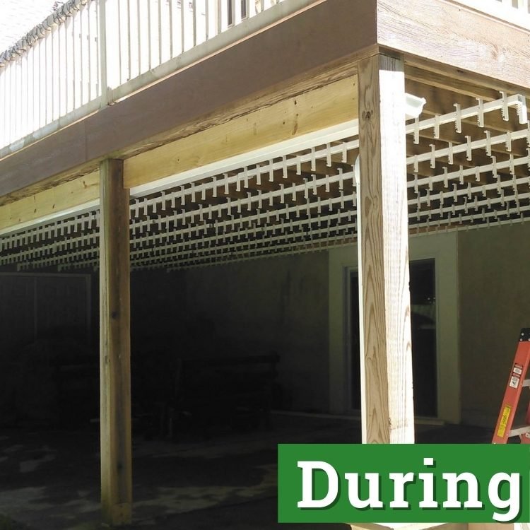 wooden beams and white deck supports under a second story deck in the process of being built