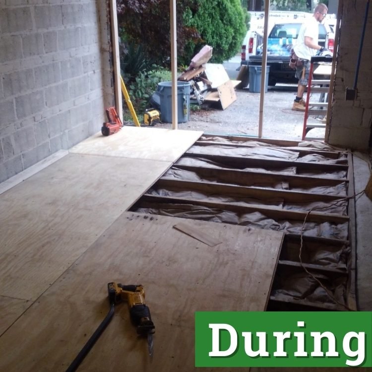 a man stands in the driveway in front of an unfinished converted garage