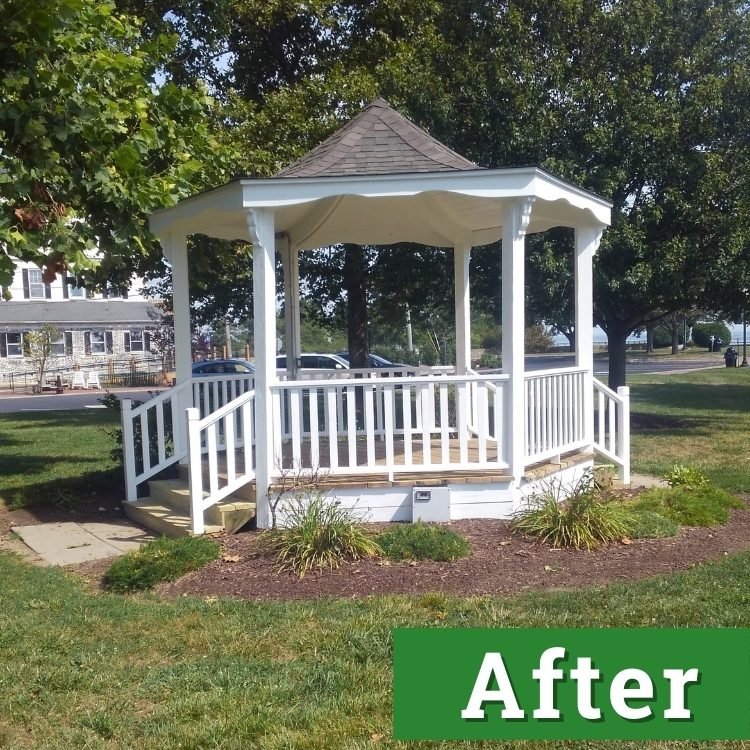 a newly painted white gazebo shines under the sun