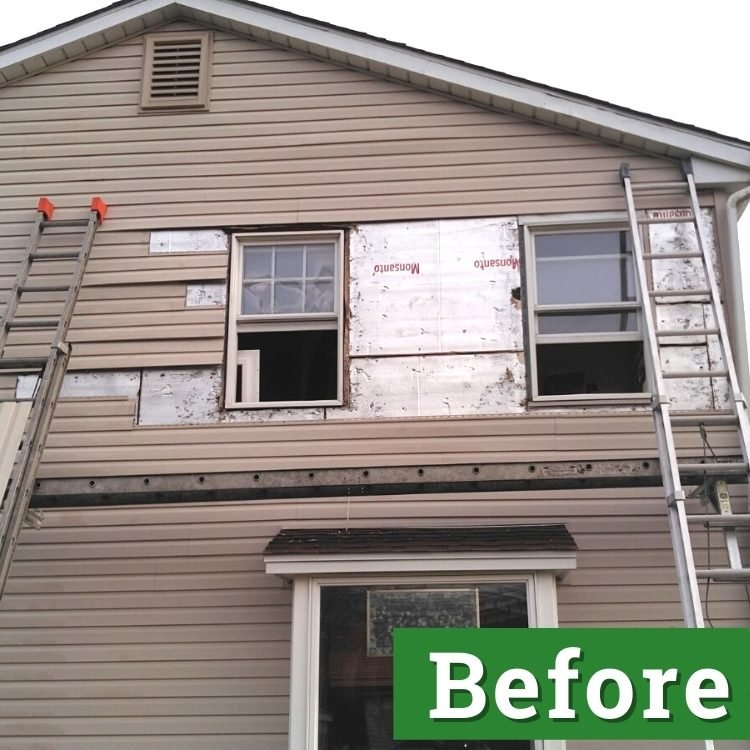 two ladders lean against storm-damaged siding of a brown house