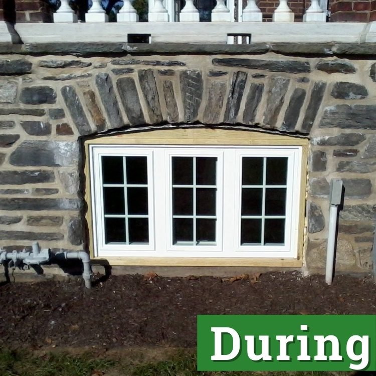 a white three pane basement window under construction